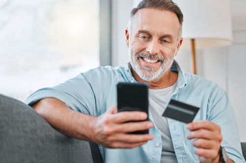 Mann mit Mobiltelefon und Kreditkarte